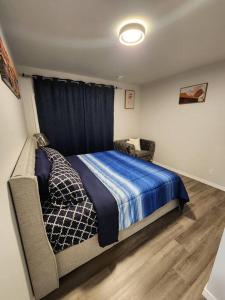 a bedroom with a bed and a chair in it at Cozy one bedroom in Airdrie in Airdrie