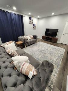 uma sala de estar com um sofá e uma televisão de ecrã plano em Cozy one bedroom in Airdrie em Airdrie