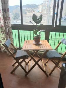 uma mesa e cadeiras com um vaso de plantas numa varanda em Room in Shared apartment with Parking em Almuñécar