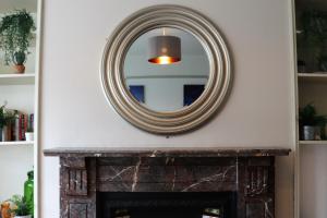 un espejo sobre una chimenea en la sala de estar en St Rhadagunds Cottage East - Pet friendly en Ventnor