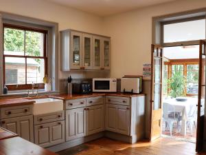 cocina con fregadero y microondas en St Rhadagunds Cottage East - Pet friendly en Ventnor