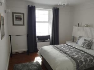 a bedroom with a bed with blue curtains and a window at Old Castle in Pembrokeshire