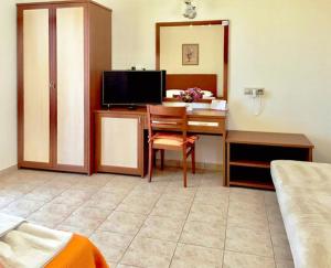 um quarto com uma secretária, uma televisão e uma cama em Anthi Studios em Agia Anna Naxos