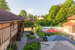una vista aérea de un patio trasero con sombrillas y una piscina en Gite les oiseaux_A Louvemont avec piscine chauffée, en Louvemont