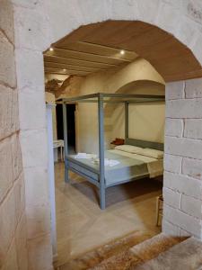 オストゥーニにあるMasseria Piccole Taverneのレンガの壁に二段ベッドが備わるベッドルーム1室が備わります。