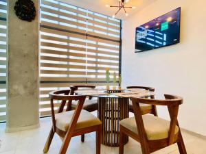a dining room with a table and chairs and a tv at Luxurious and Modern Apartment in North Zone in Aguascalientes
