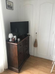 a living room with a television on a wooden dresser at vacances in Urrugne