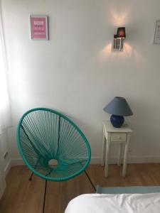 een blauwe stoel in een kamer met een lamp en een tafel bij vacances in Urrugne