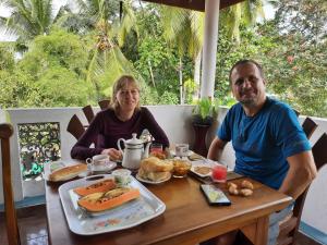 een man en een vrouw aan een tafel met een bord eten bij Guest House Basilea in Beruwala