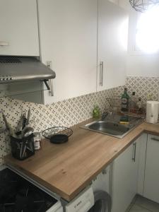 a kitchen with a wooden counter top and a sink at vacances in Urrugne