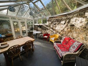 a conservatory with a couch and a table and chairs at 2 Apse Castle Cottages Charming 16th-Century Cottage in Shanklin - Dog-Friendly, Parking, Near Beach Sleeps 5 in Shanklin +22 photos