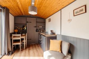 una pequeña cocina con mesa y silla en una habitación en Cefn Crib Cabins en Machynlleth