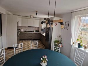 a kitchen and dining room with a blue table and chairs at Gold Residence in Ocna-Mureşului