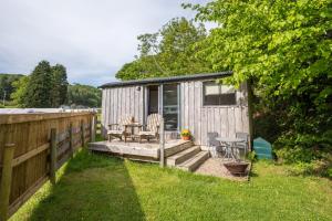 a small shed with a table and chairs in a yard at Cefn Crib Cabins in Machynlleth