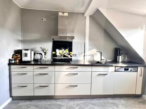 a kitchen with white cabinets and a stove at 65qm Luxus Apartment mit Whirlpool Saarbrücken Uni Nähe in Saarbrücken