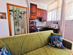 a living room with a green couch in a kitchen at OSTIA HOME in Lido di Ostia