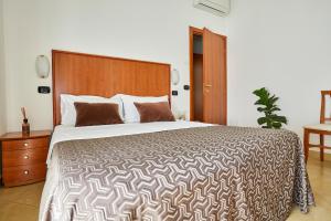 a bedroom with a large bed with a wooden headboard at Residence Fellini in Rimini