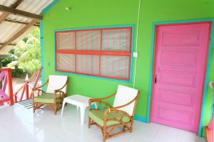 une chambre avec quatre chaises et une porte rose dans l'établissement Cabaña en San Antero con 6 habitaciones y AC, à San Antero