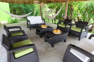 a group of chairs and tables on a patio at Cabaña en primera línea de playa en San Antero con Aire AC y 5 habitaciones in San Antero