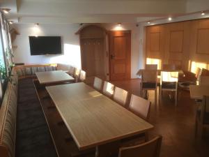 a restaurant with tables and chairs and a flat screen tv at Gasthof Zur Krone in Leidersbach