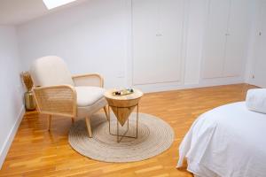 - une chambre avec une chaise, une table et un lit dans l'établissement El Deseo del Carmen, à El Burgo de Osma