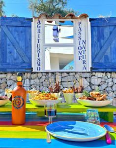 una mesa con platos de comida y una botella de salsa en Agriturismo Passione Natura, en Vieste