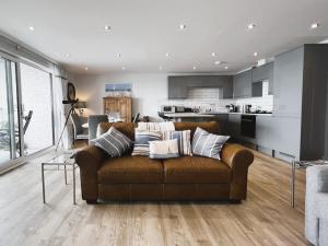 sala de estar con sofá marrón y cocina en 25 Breakwaters - Pet friendly, en Sandown