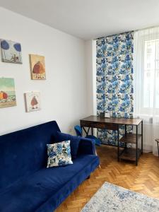 a blue couch in a living room with a table at Apartament Marszałkowska in Warsaw