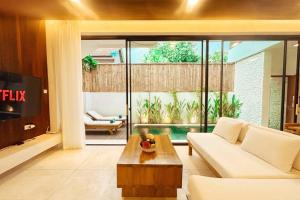 スミニャックにあるVilla Prada II 3BR Villa Near to Beach in Seminyakの白いソファとテレビのあるリビングルーム