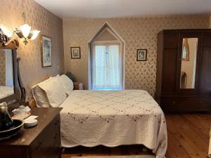 a bedroom with a bed and a dresser and a mirror at Manoir Guay Lafontaine in Rimouski