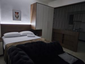 a bedroom with a bed and a chair in it at Loft Central in Passo Fundo