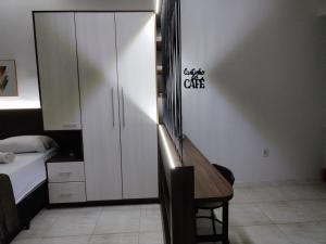 a bedroom with a desk and a bed and a cabinet at Loft Central in Passo Fundo