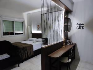 a bedroom with a bed and a desk and a desk at Loft Central in Passo Fundo