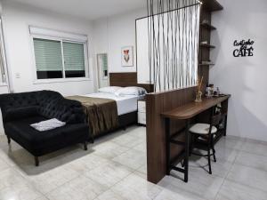 a bedroom with a bed and a desk and a chair at Loft Central in Passo Fundo