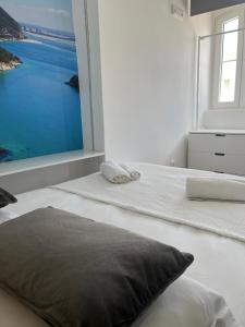 - une chambre avec une grande fenêtre et un lit avec un oreiller dans l'établissement PÉROLA DA ARRÁBIDA - no coração de Setúbal, à Setúbal