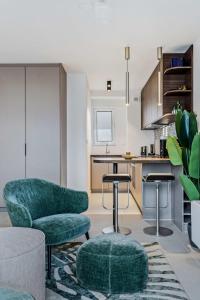 uma sala de estar com uma cadeira verde e uma cozinha em Bright Belair Gem Experience the City in Style em Luxemburgo