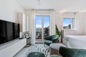 a hotel room with a bed and a large window at Stylish Studio with King Bed, Balcony and Full Kitchen in Luxembourg