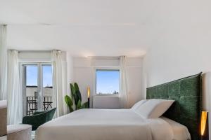 a bedroom with a white bed and a window at Stylish Studio with King Bed, Balcony and Full Kitchen in Luxembourg