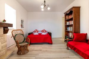a bedroom with a red bed and a chair at La Villa - Rainbow House in Martina Franca