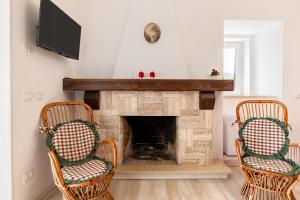 a living room with two chairs and a fireplace at La Villa - Rainbow House in Martina Franca