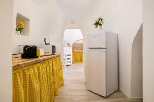 a kitchen with a white refrigerator and a yellow curtain at La Villa - Rainbow House in Martina Franca