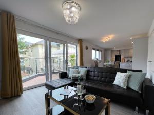 a living room with a black couch and a large window at 4 The Bayhouse in Shanklin +70 photos