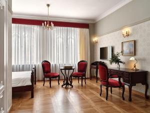 pokój hotelowy z łóżkiem, stołem i krzesłami w obiekcie Pałac Będlewo w mieście Będlewo