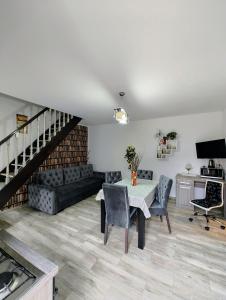 ein Wohnzimmer mit einem Tisch und einem Sofa in der Unterkunft House Apartment Minerilor in Cluj-Napoca