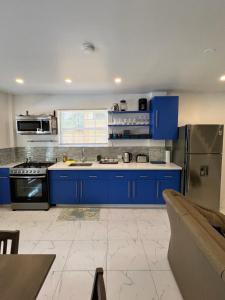 cocina grande con armarios y electrodomésticos azules en Tropical Apartments Tobago en Bethel