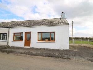a white house with brown doors and windows at Blaenferwig in New Quay