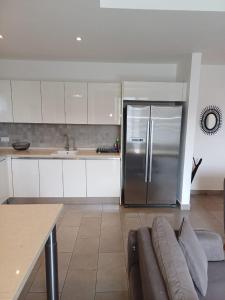 a kitchen with a stainless steel refrigerator and a couch at The Edge in Accra