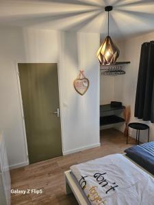 a bedroom with a bed and a green door at Chambre DUO in Beauvais