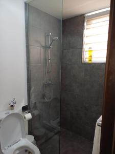 a bathroom with a glass shower with a toilet at The Edge in Accra