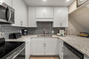 a kitchen with white cabinets and a sink at Eastern Shores on 30A by Panhandle Getaways in Seagrove Beach